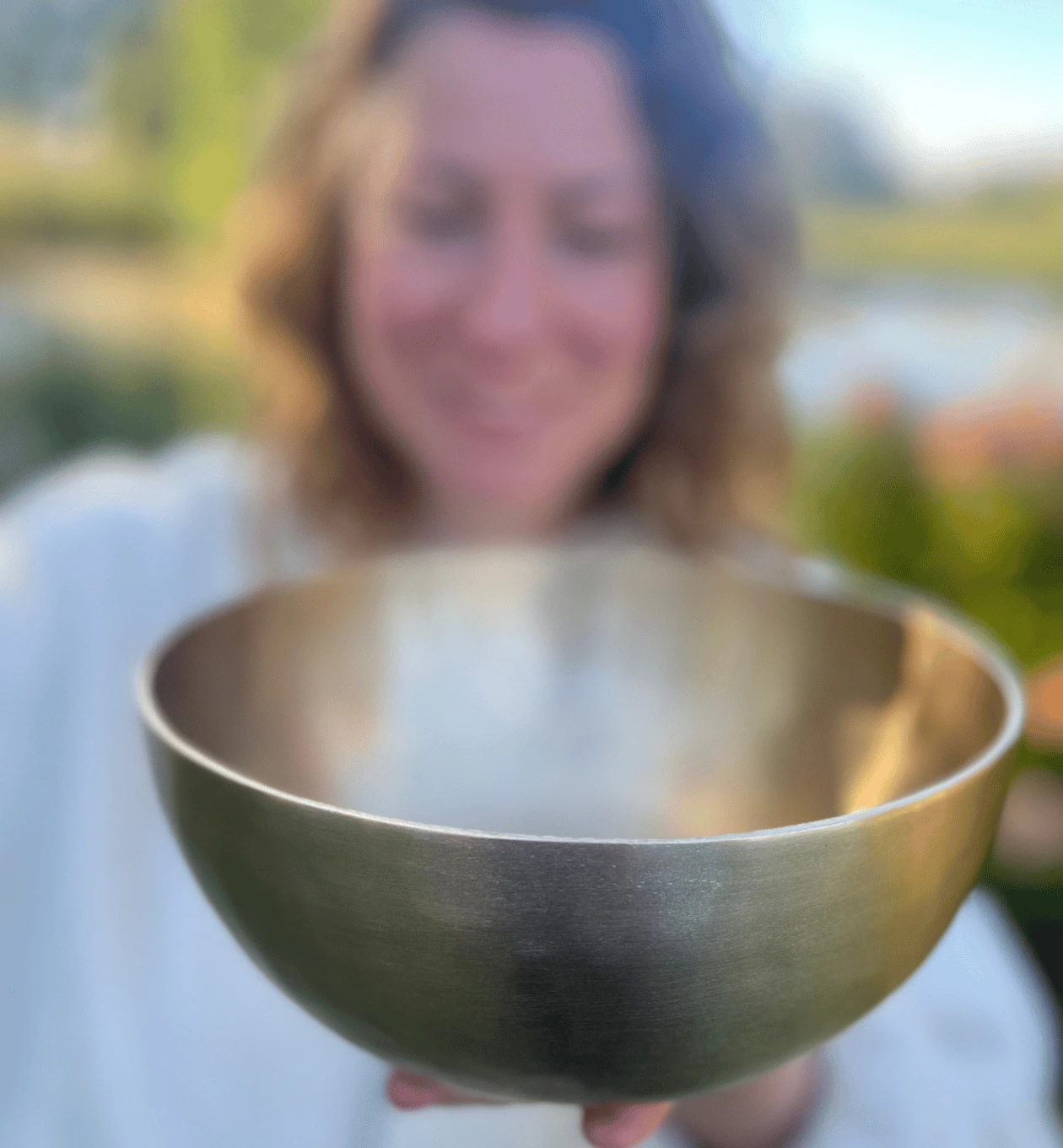 Klangschale im Vordergrund, Person im Hintergrund unscharf